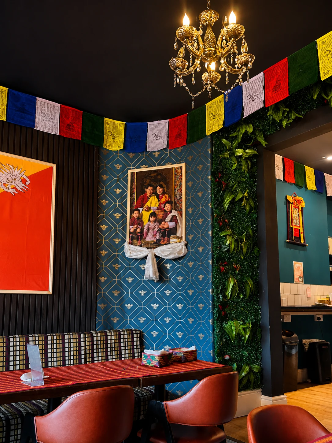 Hima-Fuji's dining room with a golden chandelier, Bhutanese prayer flags and a blue feature wall